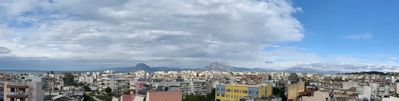 Binanın çatısından, güney Patras'ın çatıları üzerinden körfeze ve dağlara bakan fotoğraf